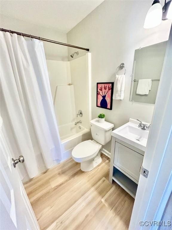 full bathroom featuring toilet, shower / bathtub combination with curtain, wood finished floors, and vanity