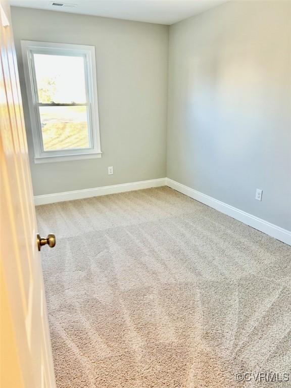 unfurnished room featuring carpet floors and baseboards