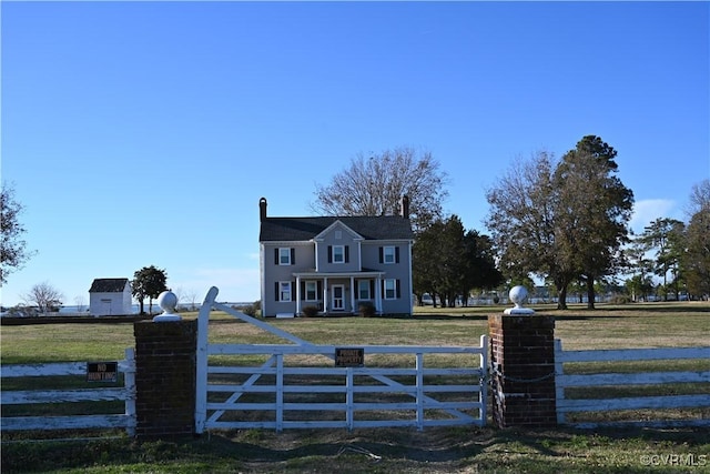 view of gate with a fenced front yard and a lawn