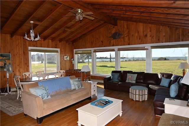 living area featuring lofted ceiling with beams, wood finished floors, a wealth of natural light, and wooden walls