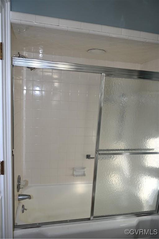 bathroom with combined bath / shower with glass door