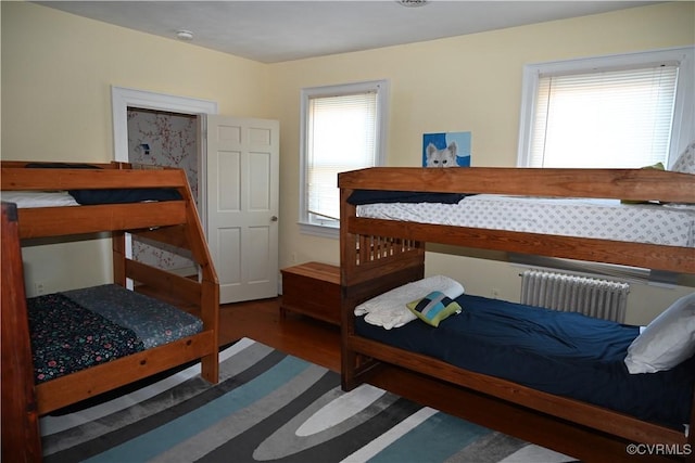 bedroom with radiator and wood finished floors