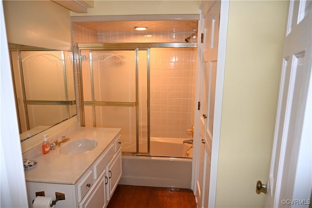 bathroom with enclosed tub / shower combo, wood finished floors, and vanity