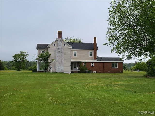 rear view of property featuring a yard