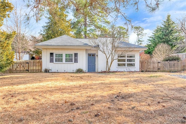 single story home with a front lawn, fence, and a gate