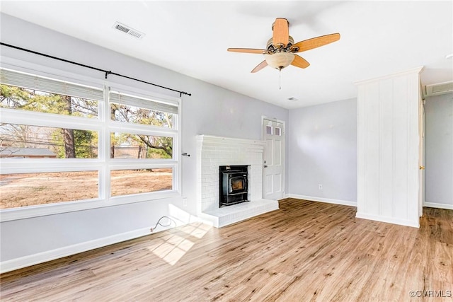 unfurnished living room with baseboards, visible vents, ceiling fan, and wood finished floors