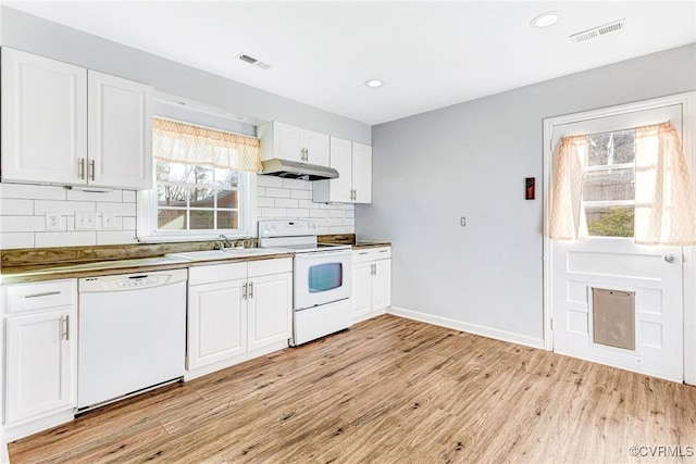 kitchen with visible vents, a sink, light wood-type flooring, white appliances, and under cabinet range hood