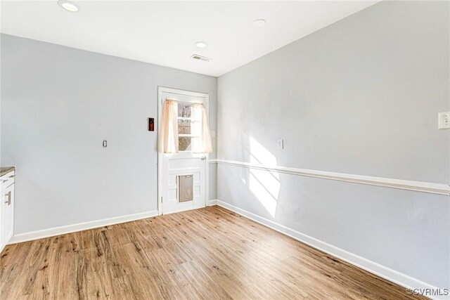 unfurnished room with recessed lighting, visible vents, light wood-style flooring, and baseboards