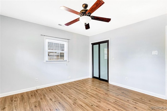 unfurnished room featuring light wood finished floors, plenty of natural light, and baseboards