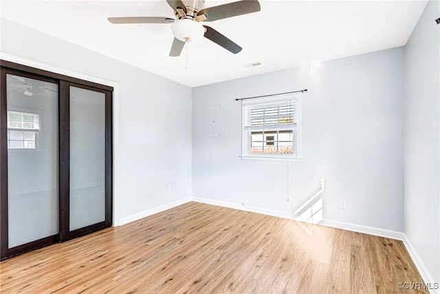 empty room featuring visible vents, a ceiling fan, light wood-style flooring, and baseboards