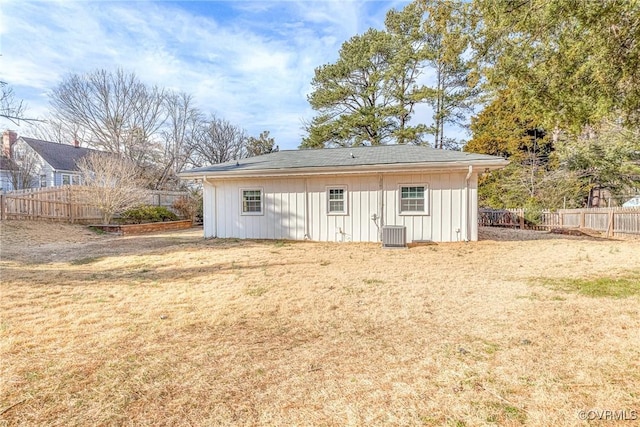 exterior space featuring board and batten siding, fence, cooling unit, and a yard