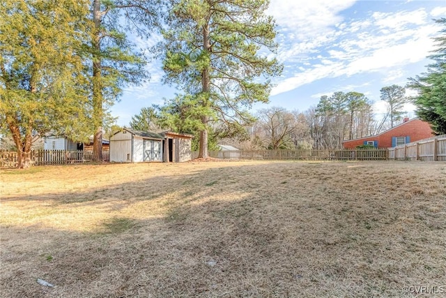 view of yard featuring a storage shed, an outdoor structure, and a fenced backyard