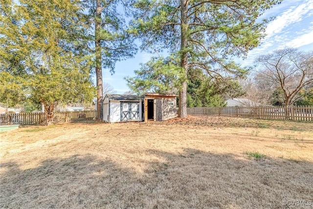 view of yard with a fenced backyard, a storage unit, and an outdoor structure