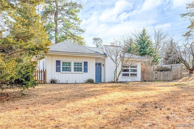 view of front of house featuring board and batten siding and fence