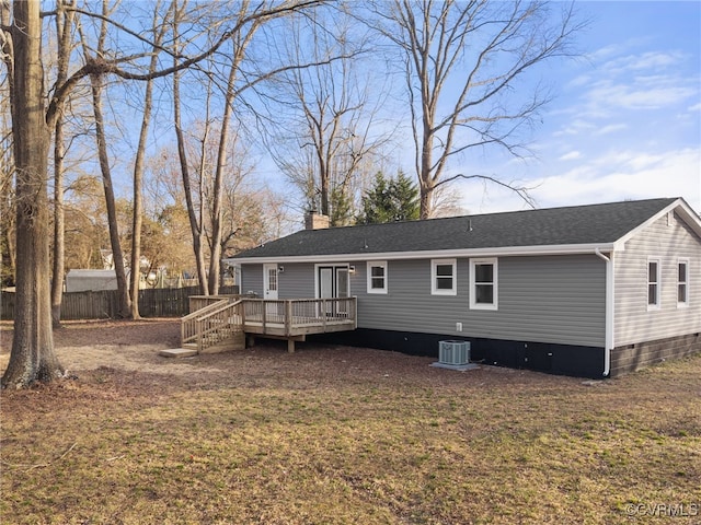 rear view of property with fence, a wooden deck, central AC, a lawn, and a chimney