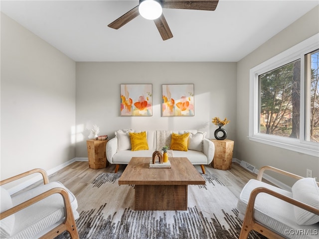 interior space with a ceiling fan, light wood-style flooring, baseboards, and visible vents