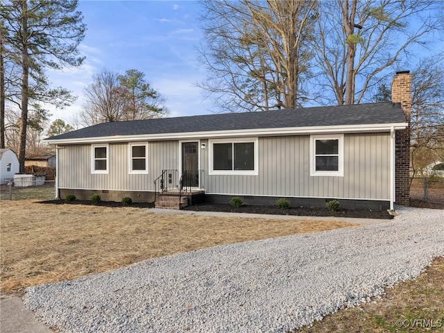 ranch-style house featuring crawl space, a chimney, roof with shingles, and fence