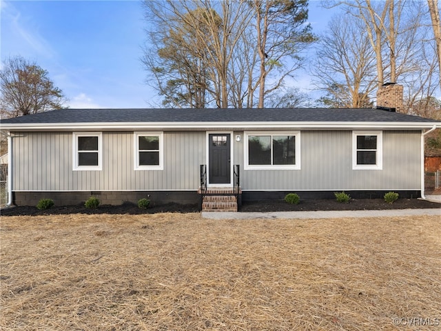 view of front of home featuring a chimney and a shingled roof