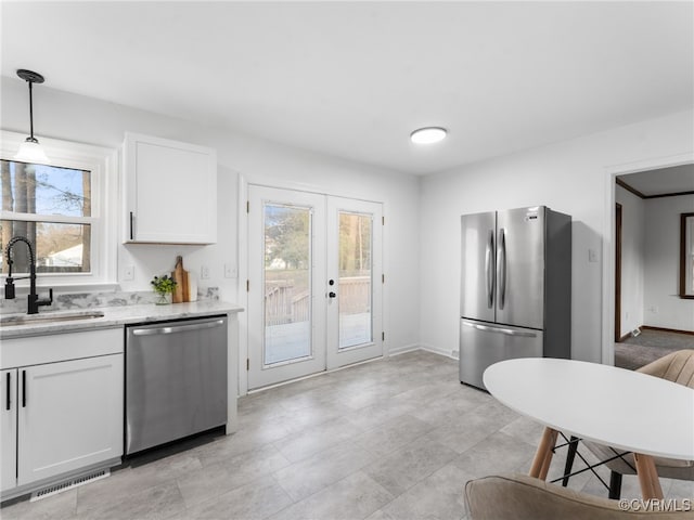 kitchen with visible vents, a sink, white cabinetry, stainless steel appliances, and french doors