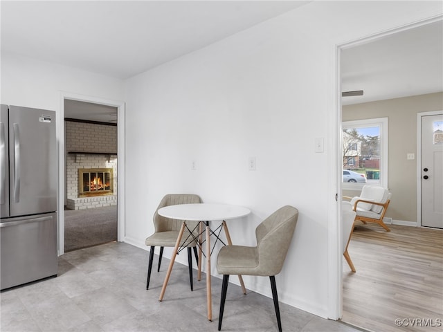 dining area with a fireplace and baseboards