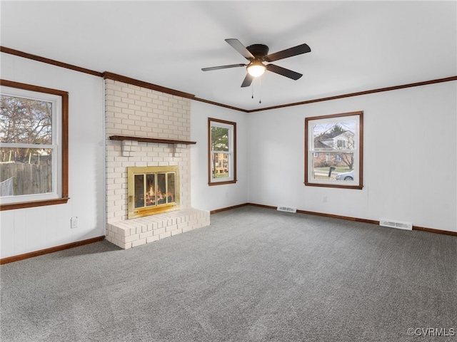 unfurnished living room featuring crown molding, a brick fireplace, carpet, and visible vents