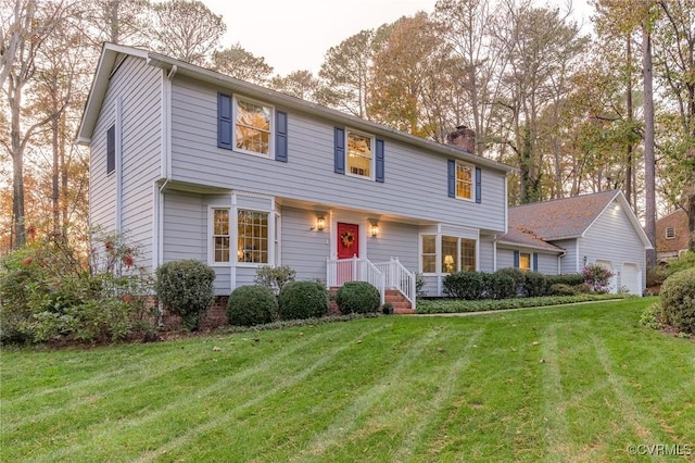 colonial home with a front lawn and a chimney