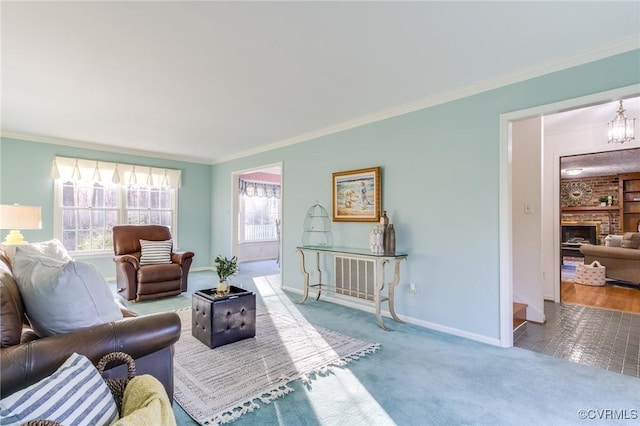 carpeted living room featuring a chandelier, a brick fireplace, crown molding, and baseboards