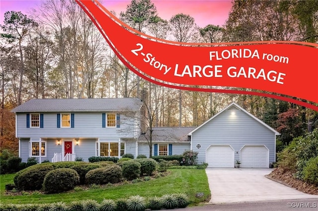 view of front of house with a garage, driveway, and a lawn