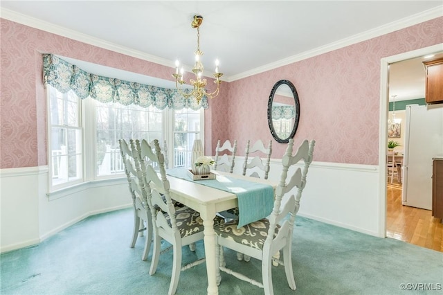 dining room featuring a chandelier, wainscoting, light carpet, and wallpapered walls