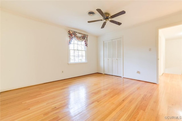 unfurnished bedroom with a ceiling fan, a closet, visible vents, and light wood-style floors