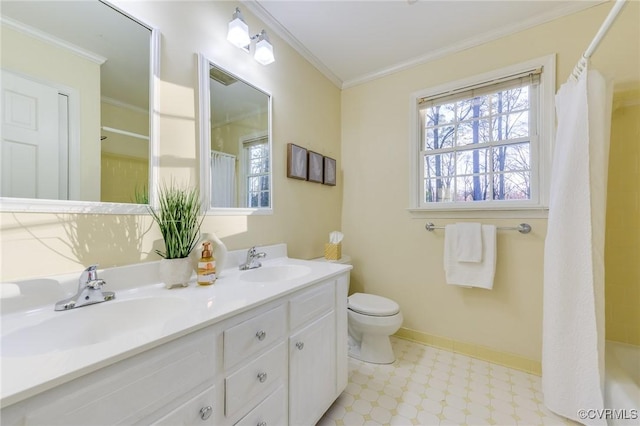 bathroom featuring crown molding, a sink, baseboards, and double vanity