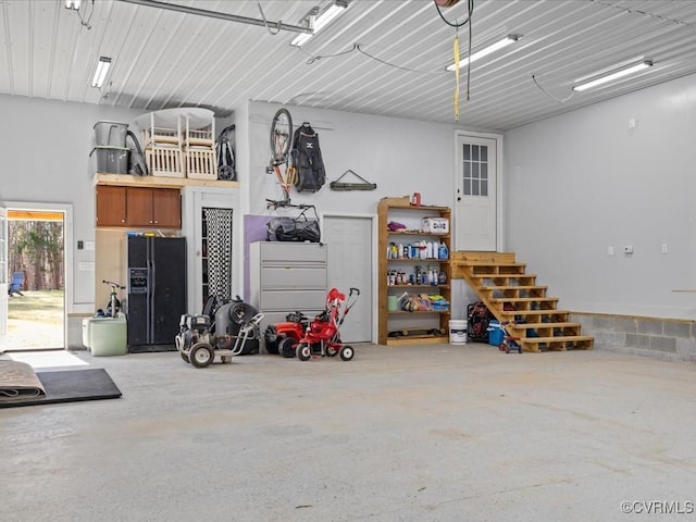 garage with black fridge with ice dispenser