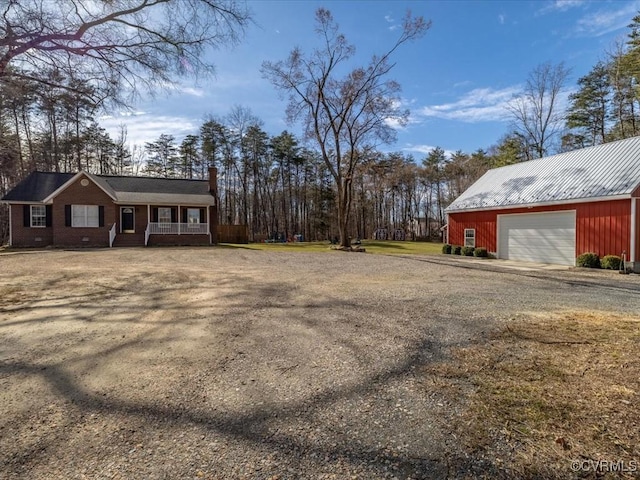 view of yard with an outbuilding, a detached garage, and dirt driveway