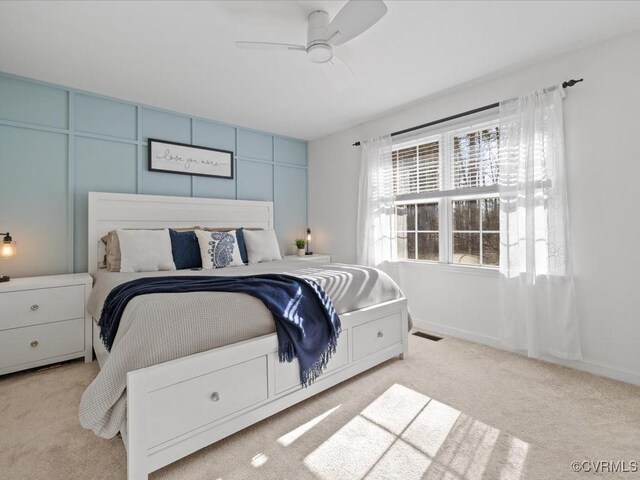 carpeted bedroom featuring visible vents and a ceiling fan