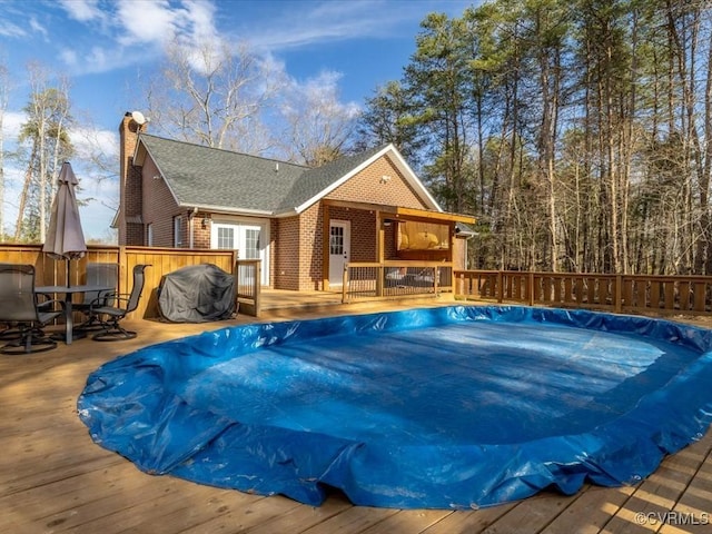 view of pool featuring a wooden deck and outdoor dining space