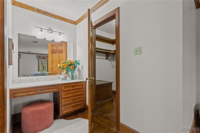 bathroom with crown molding, vanity, and wood finished floors