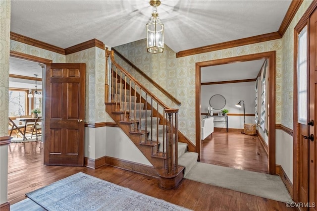 staircase featuring baseboards, hardwood / wood-style flooring, and wallpapered walls