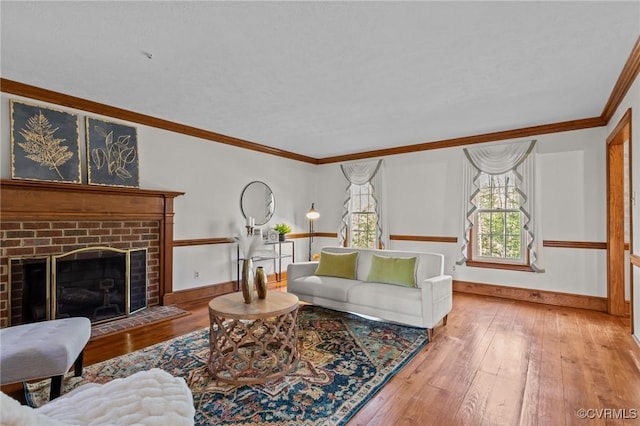 living room featuring ornamental molding, a fireplace, hardwood / wood-style floors, and baseboards