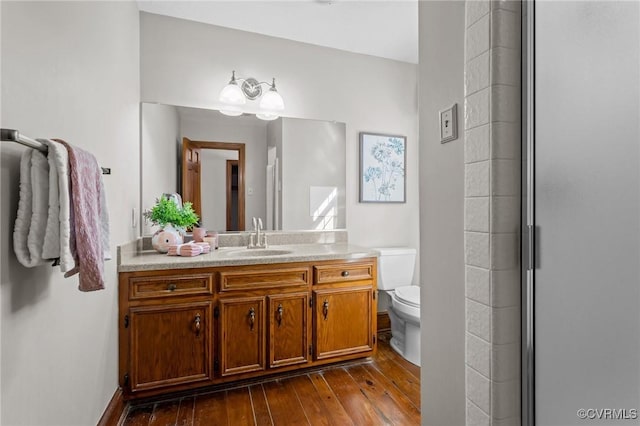 full bathroom featuring a stall shower, wood-type flooring, vanity, and toilet