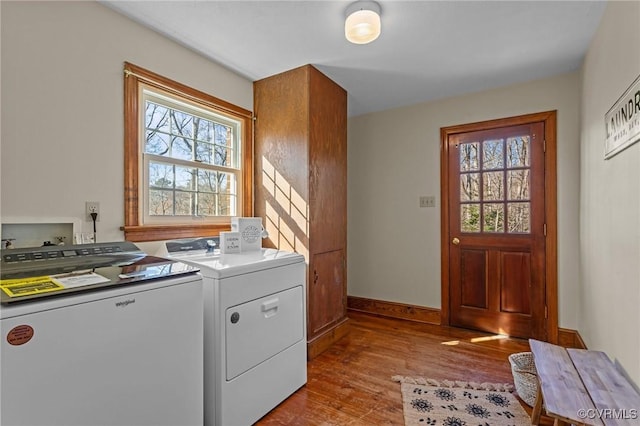 washroom with washing machine and dryer, laundry area, plenty of natural light, and wood finished floors