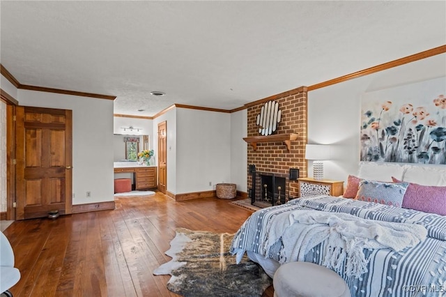 bedroom with ornamental molding, hardwood / wood-style floors, a fireplace, and baseboards