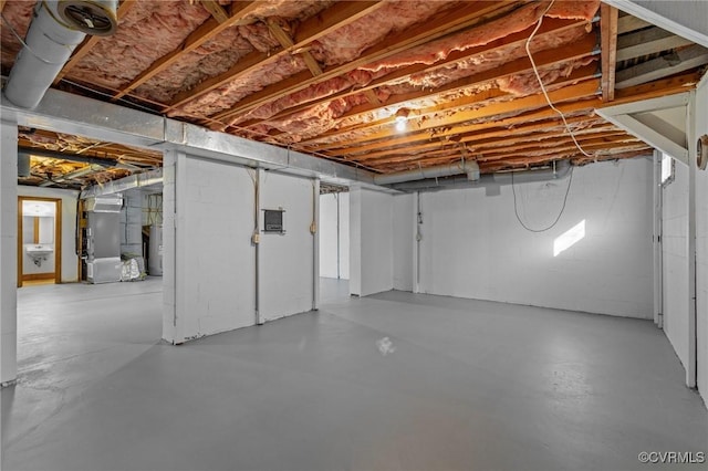 unfinished basement featuring heating unit and water heater