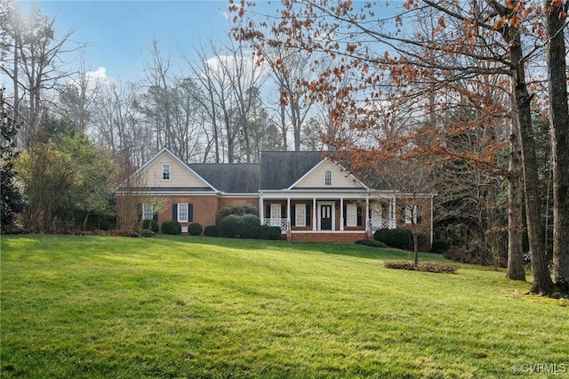 view of front of home with covered porch, brick siding, and a front yard