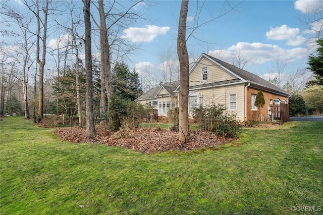 view of side of home featuring a yard and brick siding