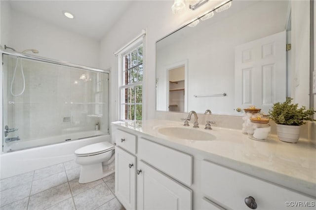 bathroom featuring combined bath / shower with glass door, vanity, toilet, and tile patterned floors