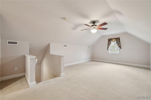 bonus room featuring visible vents, vaulted ceiling, light carpet, and baseboards