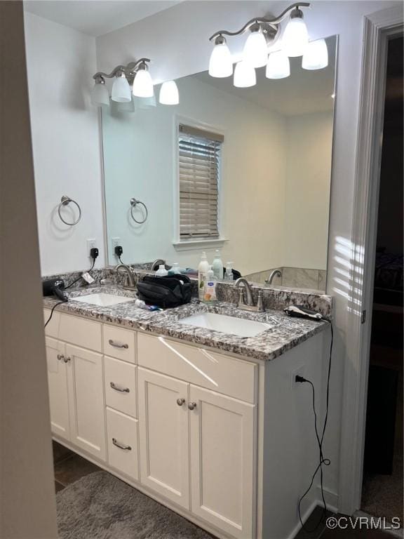 full bath featuring double vanity, tile patterned flooring, and a sink