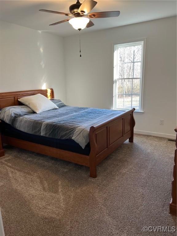 carpeted bedroom with ceiling fan and baseboards