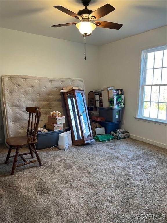 sitting room featuring baseboards, carpet floors, and ceiling fan