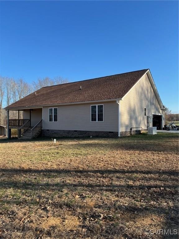 back of house with central air condition unit and a lawn